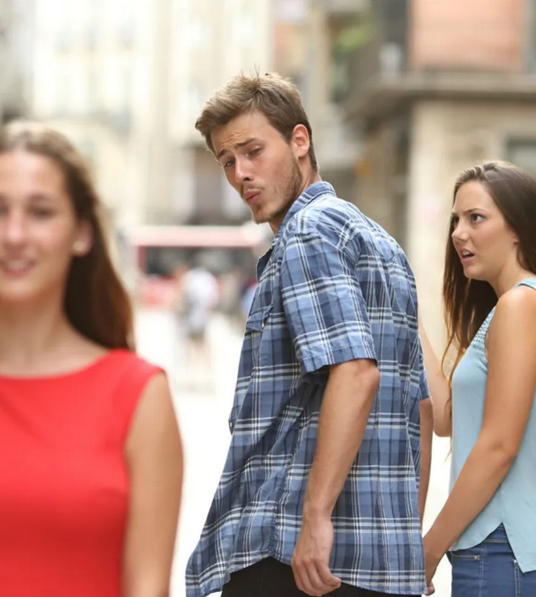 Photo: A guy is looking at a woman in a red dress and possibly whistling at her. Next to him is his girlfriend with a blue top, staring angrily at him from the side.